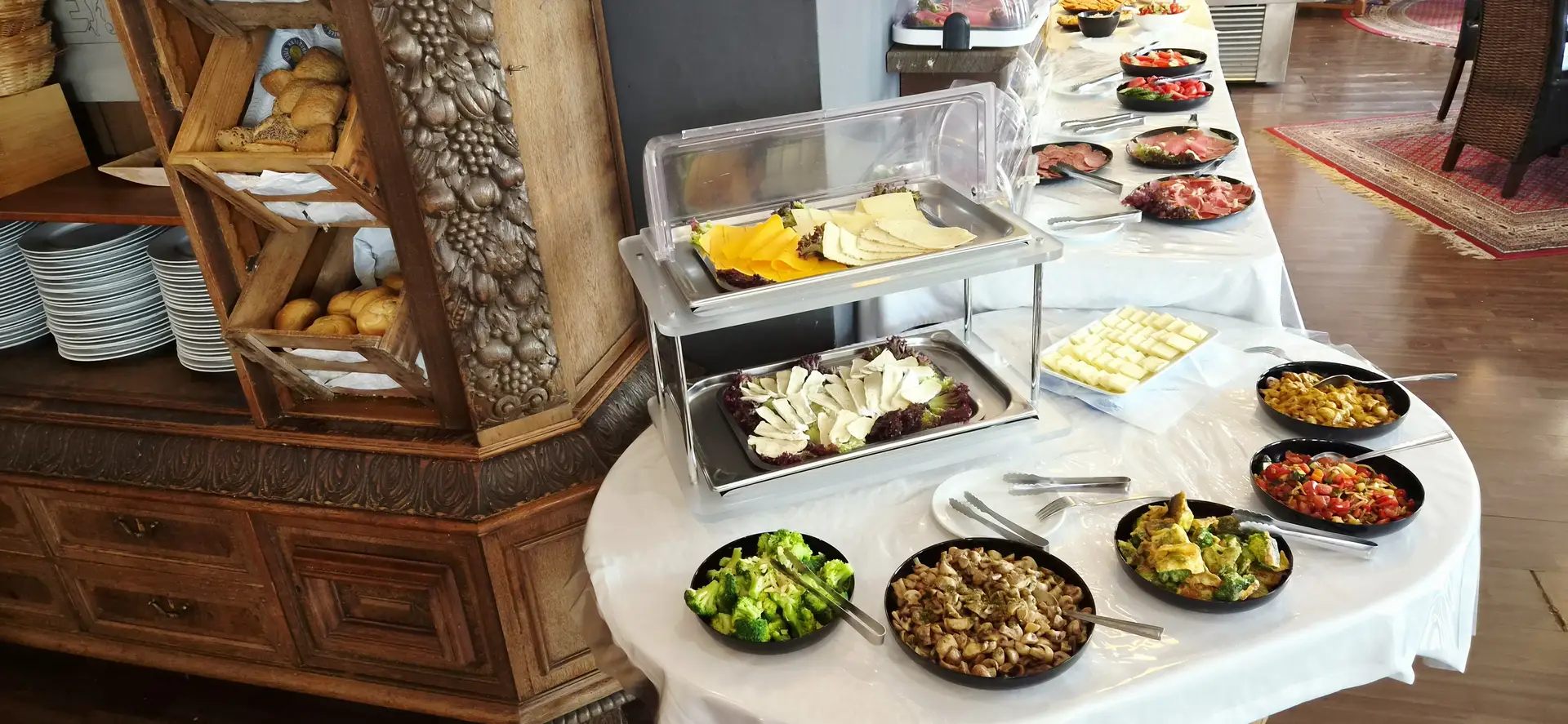 Ein reichhaltiges Buffet mit Kaese Broetchen Broccoli und bunten Salaten