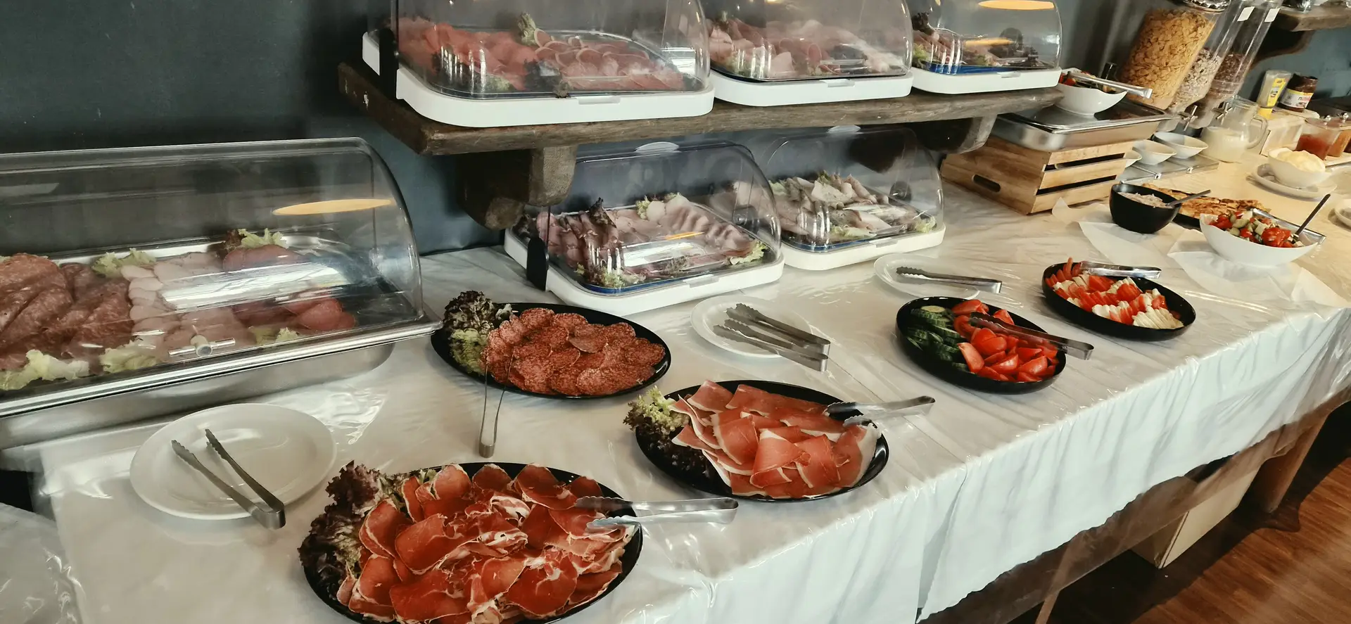 Ein Frühstücksbuffet mit Wurst Aufschnitt und frischem Gemüse auf Tellern