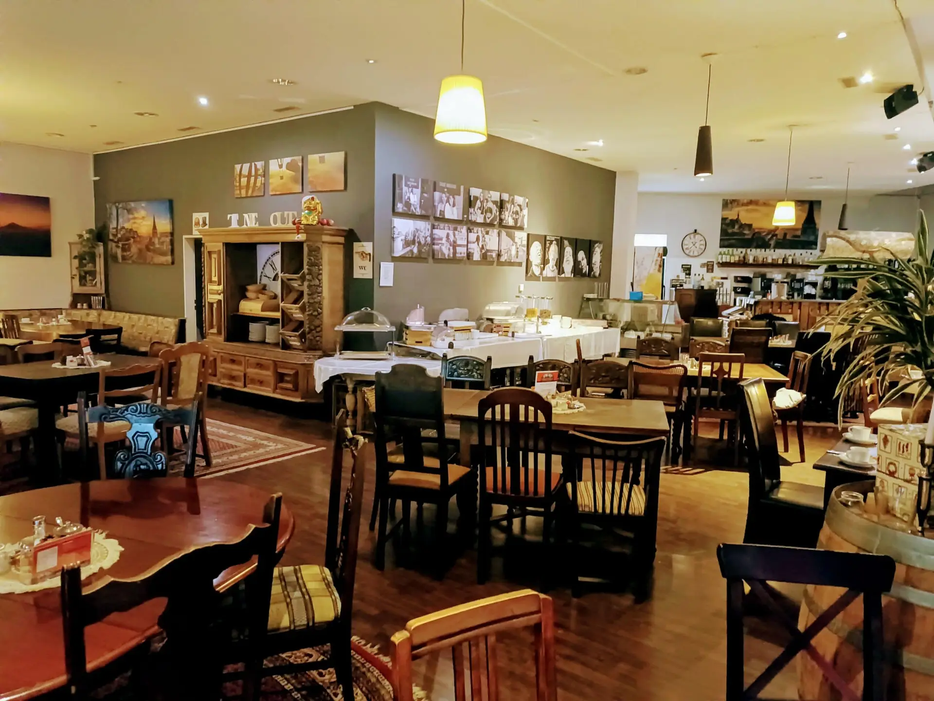 Gemuetliches Restaurant mit Holzmoebeln, warmer Beleuchtung und Buffettischen